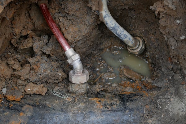 FILE - A copper water supply line, left, is shown connected to a water main after being installed for lead pipe, right, in Flint, Mich., Friday, July 20, 2018. (AP Photo/Paul Sancya, File)