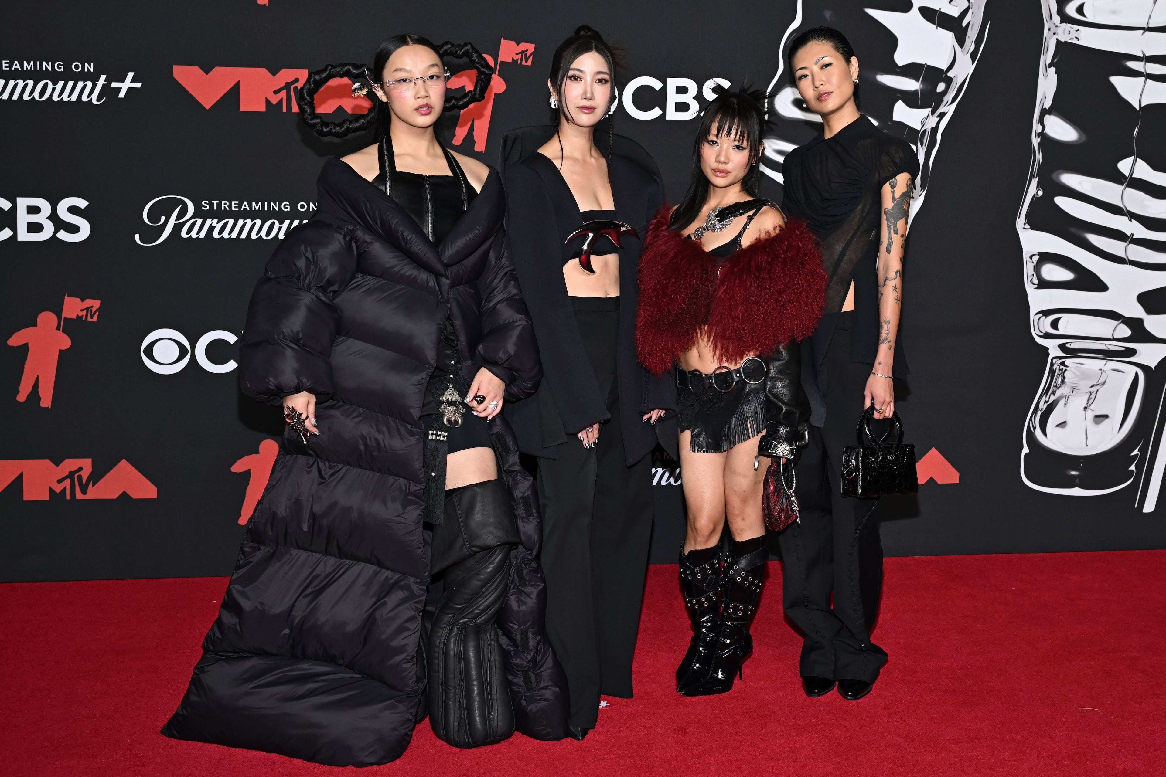 From left, "KPop Demon Hunters" voice actors Audrey Nuna, Ejae, Rei Ami and May Hong arrive at the MTV Video Music Awards earlier this month. Hong provides the speaking voice for the character Mira, while the singing voices are provided by Nuna (Mira), Ejae (Rumi) and Ami (Zoey). (Evan Agostini/AP)