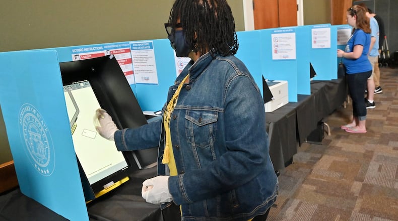 June 9, 2020 Duluth - Loretta McCullough, poll worker, wipes down a voting machine as Gwinnett County residents cast their votes during the Georgia primary elections at Pleasant Hill Presbyterian Church in Duluth on Tuesday, June 9, 2020. (Hyosub Shin / Hyosub.Shin@ajc.com)