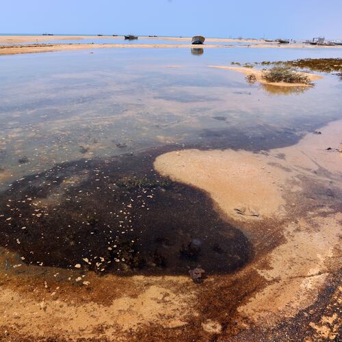 Dark oil residue collects in shallow coastal waters on Qeshm Island, Iran, Thursday, Aug. 13, 2026, amid ongoing wartime attacks on vessels and infrastructure in and around the Strait of Hormuz, though the spill's source has not been independently determined.(Amirhosein Khorgooi/ISNA via AP)