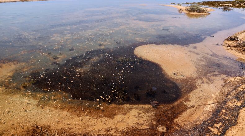 Dark oil residue collects in shallow coastal waters on Qeshm Island, Iran, Thursday, Aug. 13, 2026, amid ongoing wartime attacks on vessels and infrastructure in and around the Strait of Hormuz, though the spill's source has not been independently determined.(Amirhosein Khorgooi/ISNA via AP)