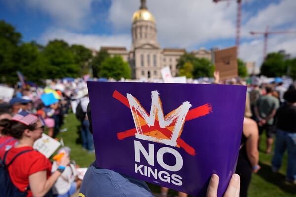 A demonstrator holds a sign during a "No Kings" protest, Saturday, June 14, 2025, in Atlanta. (AP Photo/Mike Stewart)