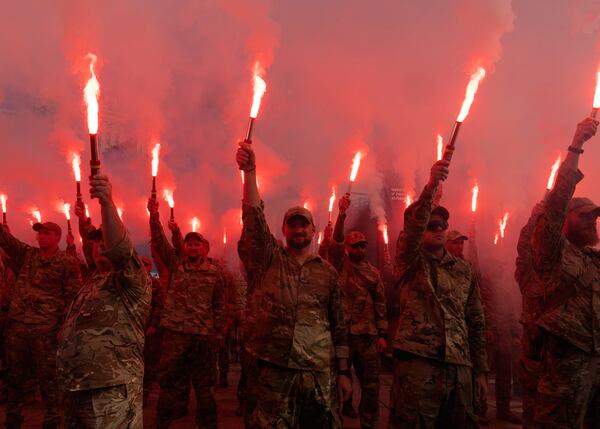 FILE - Soldiers of Ukraine's Azov battalion light flares at a rally demanding the release of Ukrainian prisoners of war who are held in captivity in Russia, at Independence Square in Kyiv, Ukraine, Sunday, July 28, 2024. (AP Photo/Efrem Lukatsky, File)