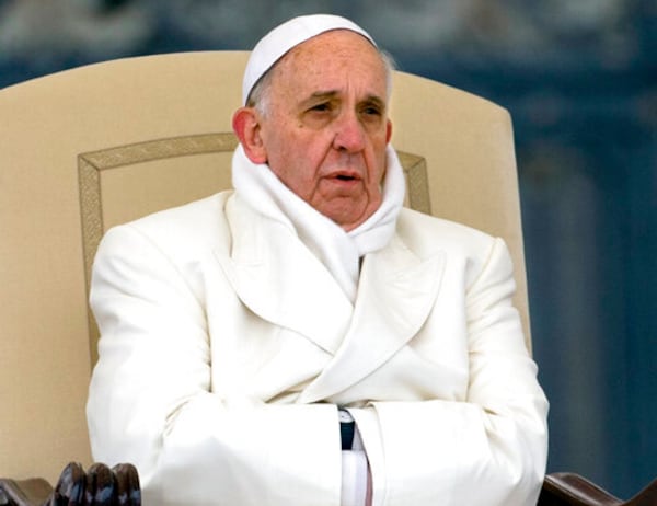 FILE - Pope Francis tries to keep himself warm as he attends his weekly general audience in St. Peter's Square at the Vatican, Wednesday, Nov. 27, 2013. (AP Photo/Alessandra Tarantino, File )