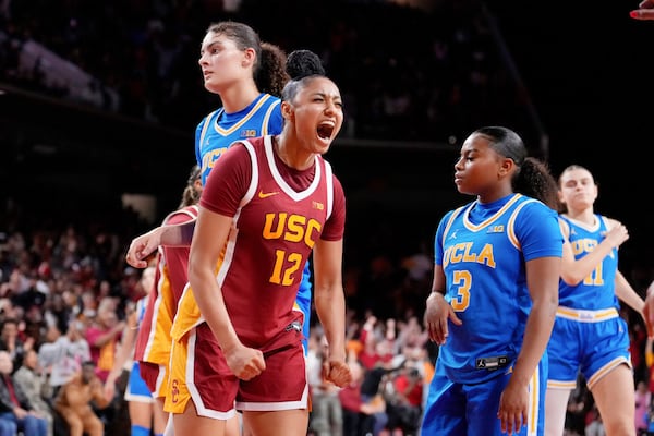 FILE - Southern California guard JuJu Watkins (12) celebrates after scoring as UCLA center Lauren Betts (51) and guard Londynn Jones (3) look on during the second half of an NCAA college basketball game, Thursday, Feb. 13, 2025, in Los Angeles. (AP Photo/Mark J. Terrill, File)