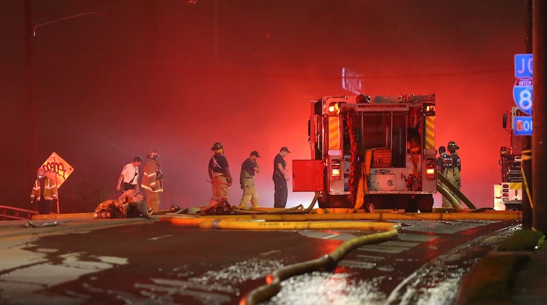 Firefighters work on Piedmont Road as smoke fills the sky at the scene of a bridge collapse at I-85 on Thursday, March 30, 2017, in Atlanta. Curtis Compton/ccompton@ajc.com