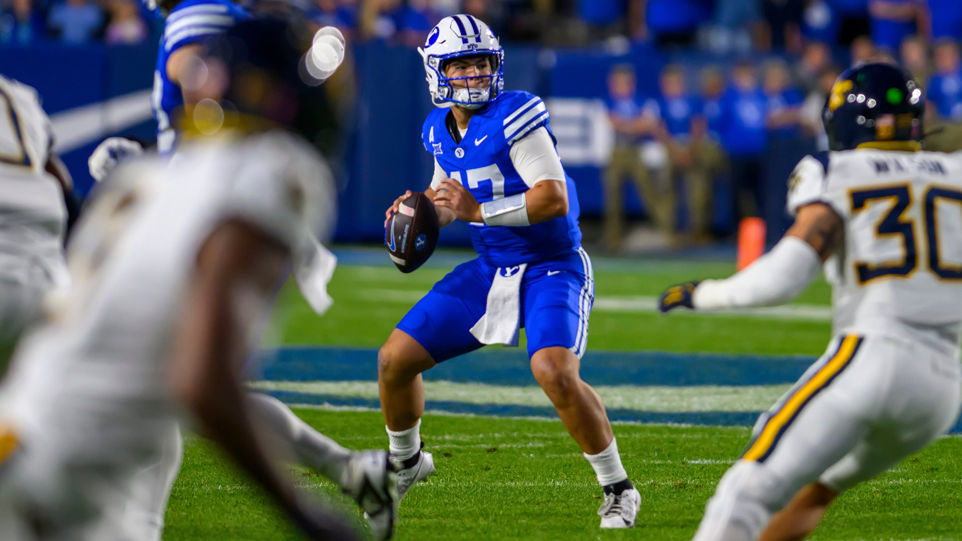 BYU quarterback Bear Bachmeier, center, looks to pass the ball during the first half of an NCAA college football game against West Virginia, Friday, Oct. 3, 2025, in Provo, Utah. (AP Photo/Tyler Tate)