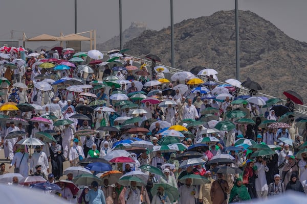 FILE - Muslim pilgrims use umbrellas to shield themselves from the sun as they arrive to cast stones at pillars in the symbolic stoning of the devil during the annual hajj, in Mina, near the holy city of Mecca, Saudi Arabia, Tuesday, June 18, 2024. (AP Photo/Rafiq Maqbool, File)