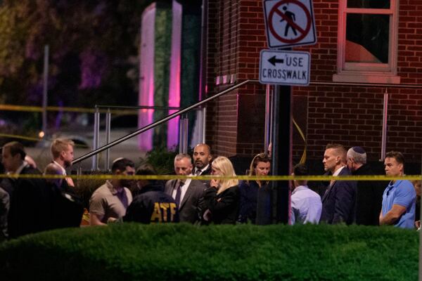 Attorney General Pam Bondi, center, walks to her car as law enforcement work the scene after two staff members of the Israeli Embassy in Washington were shot and killed outside the Capital Jewish Museum, Thursay, May 22, 2025, in Washington. (AP Photo/Rod Lamkey, Jr.)