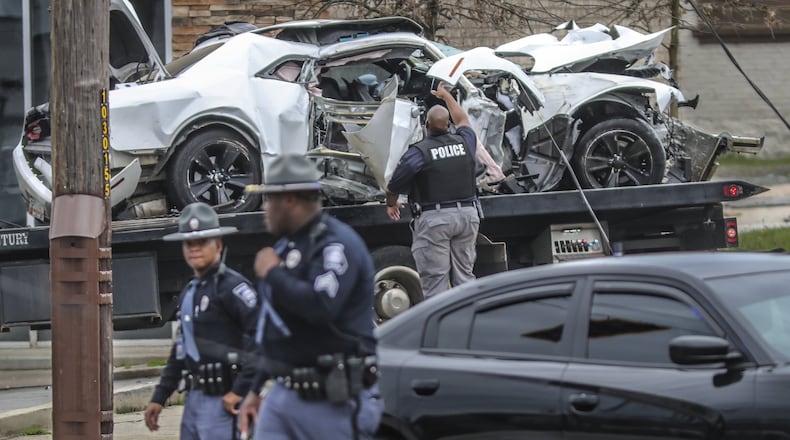 Capitol police walk along Northside Drive following a crash that triggered a police search for a driver they say led officers on a chase through northwest Atlanta on March 1, 2019, before crashing into two power poles and taking off on foot. JOHN SPINK/JSPINK@AJC.COM