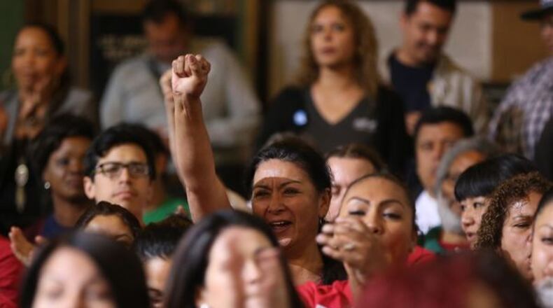 Will these folks remain happy when they learn the unions want to negotiate their wages downward? (AP Photo / Damian Dovarganes)