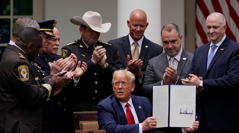Law enforcement officials applaud after President Donald Trump signed an executive order on policing in the Rose Garden of the White House, Tuesday, June 16, 2020, in Washington. (AP Photo/Evan Vucci)