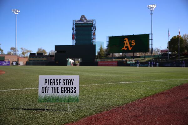 A keep of the grass sign is posted to help limit the damage to the grass before a baseball game between the Athletics and Chicago Cubs at Sutter Health Park, Wednesday, April 2, 2025, in West Sacramento, Calif. (AP Photo/Scott Marshall)