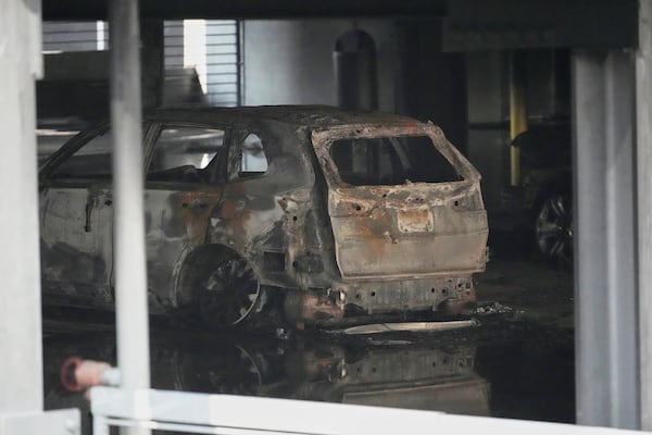 A burned vehicle is seen inside a garage that caught fire and a floor of the structure collapsed Tuesday, June 10, 2025, in Nashville, Tenn. (AP Photo/George Walker IV)