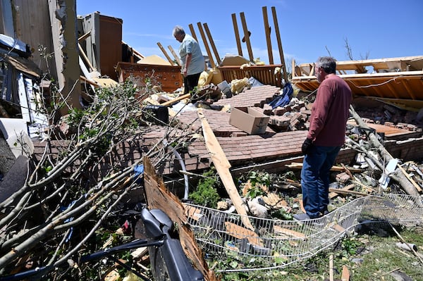 Doris Hensley, center, and Don Allen look over the remains of her home following severe weather in London, Ky., Saturday, May 17, 2025. (AP Photo/Timothy D. Easley)