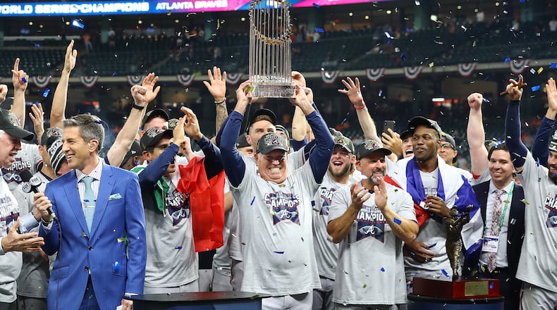 Manager Brian Snitker hoists the World Series trophy after the Braves defeated the Astros in Game 6 on Nov. 2, 2021, in Houston.  (Curtis Compton / Curtis.Compton@ajc.com)