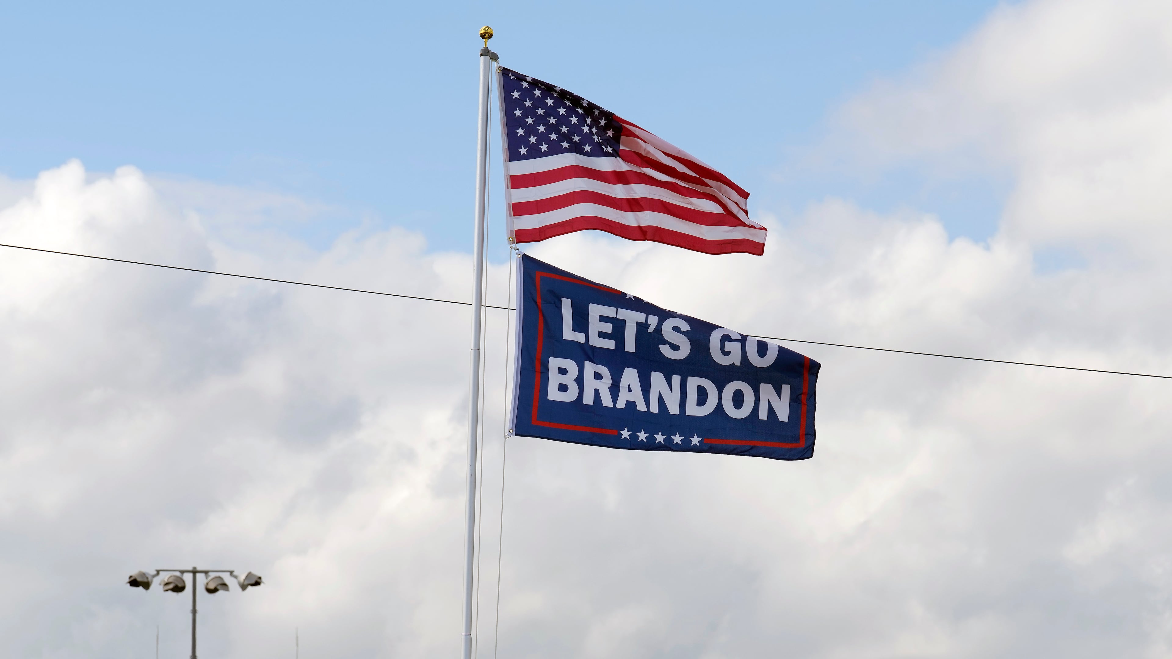 FILE - A "Let's go Brandon" flag flies below the American flag, Feb. 18, 2022, at Daytona International Speedway in Daytona Beach, Fla. (AP Photo/Chris O'Meara, File)