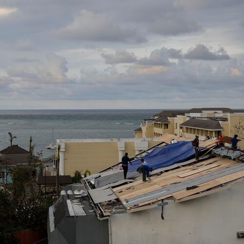 People repair the roof of a resort in Montego Bay, Jamaica, Friday, Oct. 31, 2025, in the aftermath of Hurricane Melissa. (AP Photo/Matias Delacroix)