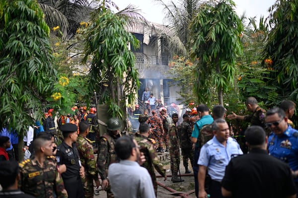 Firemen and security personnel look for the survivors after a Bangladesh Air Force training aircraft crashed into a school campus shortly after takeoff in Dhaka, Bangladesh, Monday, July 21, 2025. (AP Photo/Mahmud Hossain Opu)