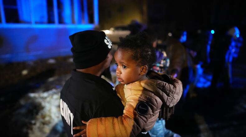 A child and family are escorted away after federal law enforcement deployed tear gas in a neighborhood during protests on Wednesday, Jan. 14, 2026, in Minneapolis. (AP Photo/Adam Gray)