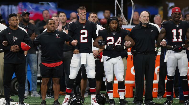 Atlanta Falcons stand arm-and-arm during the national anthem before the first half of an NFL football game between the Atlanta Falcons and the Buffalo Bills, Sunday, Oct. 1, 2017, in Atlanta. (AP Photo/John Bazemore)