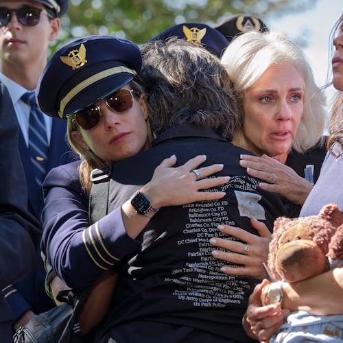 National Transportation Safety Board Chair Jennifer Homendy, center, helps to comfort Christina Stovall, center with back to camera, and Laura Augendre, right, family members of victims of flight 5342, the deadly Jan. 2025 midair collision between an American Airlines plane and a Black Hawk helicopter over the Potomac River, during a news conference on air safety reforms, at the Capitol in Washington, Tuesday, Sept. 15, 2026. (AP Photo/J. Scott Applewhite)