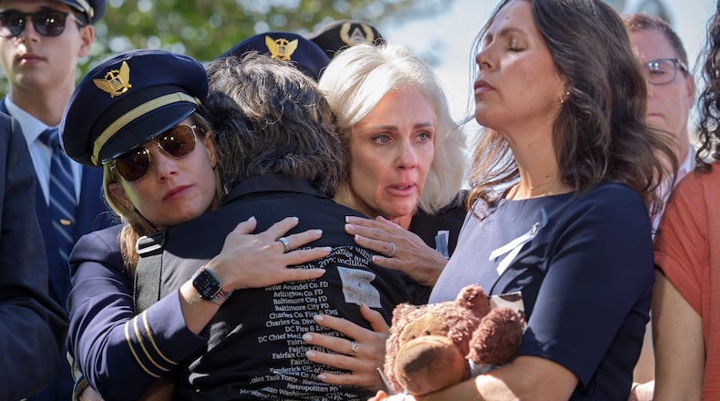 National Transportation Safety Board Chair Jennifer Homendy, center, helps to comfort Christina Stovall, center with back to camera, and Laura Augendre, right, family members of victims of flight 5342, the deadly Jan. 2025 midair collision between an American Airlines plane and a Black Hawk helicopter over the Potomac River, during a news conference on air safety reforms, at the Capitol in Washington, Tuesday, Sept. 15, 2026. (AP Photo/J. Scott Applewhite)
