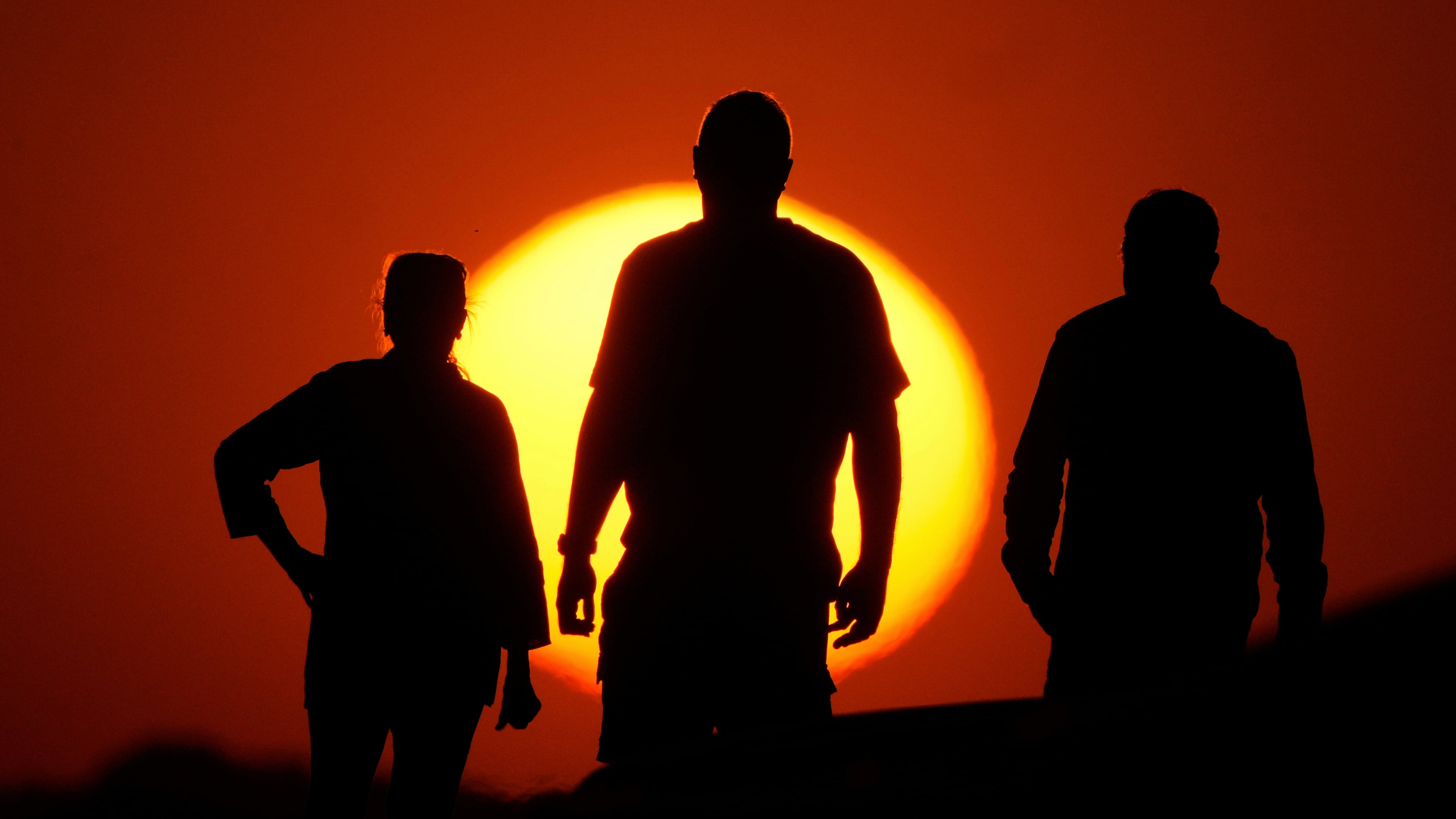 FILE - People watch the sunset from the Liberty Memorial grounds in Kansas City, Mo., May 12, 2025. (AP Photo/Charlie Riedel, File)