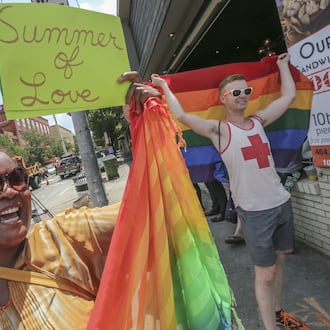 Audrey Miles (left) and Matt Bass (right) joined supporters of gay marriage that spontaneously gathered at 10th and Piedmont in Atlanta on June 26, 2015, to celebrate the U.S. Supreme Court’s ruling that same-sex couples have a constitutional right to marry. (AJC 2015)