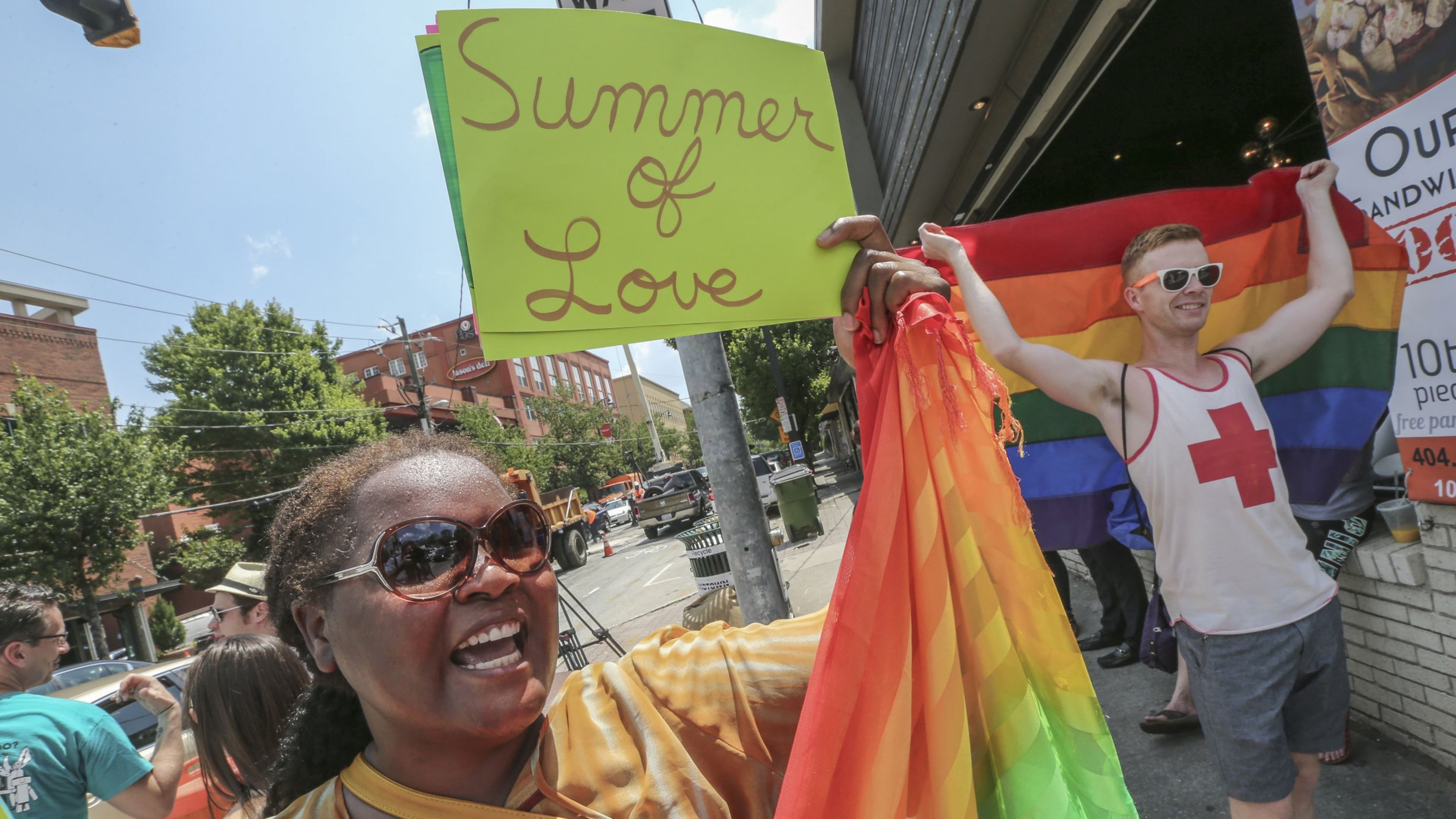 Audrey Miles (left) and Matt Bass (right) joined supporters of gay marriage that spontaneously gathered at 10th and Piedmont in Atlanta on June 26, 2015, to celebrate the U.S. Supreme Court’s ruling that same-sex couples have a constitutional right to marry. (AJC 2015)
