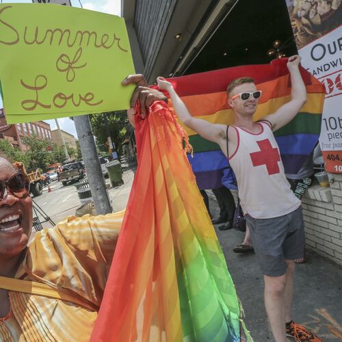 Audrey Miles (left) and Matt Bass (right) joined supporters of gay marriage that spontaneously gathered at 10th and Piedmont in Atlanta on June 26, 2015, to celebrate the U.S. Supreme Court’s ruling that same-sex couples have a constitutional right to marry. (AJC 2015)