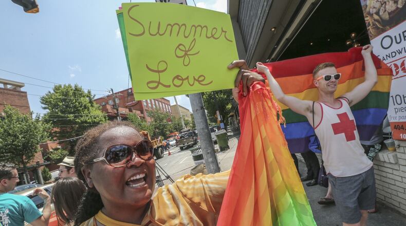 Audrey Miles (left) and Matt Bass (right) joined supporters of gay marriage that spontaneously gathered at 10th and Piedmont in Atlanta on June 26, 2015, to celebrate the U.S. Supreme Court’s ruling that same-sex couples have a constitutional right to marry. (AJC 2015)