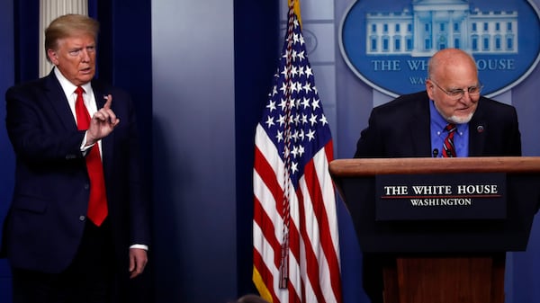 President Donald Trump listens as Dr. Robert Redfield, director of the Centers for Disease Control and Prevention, speaks about the coronavirus in the James Brady Press Briefing Room of the White House, Wednesday, April 22, 2020, in Washington. (AP Photo/Alex Brandon)