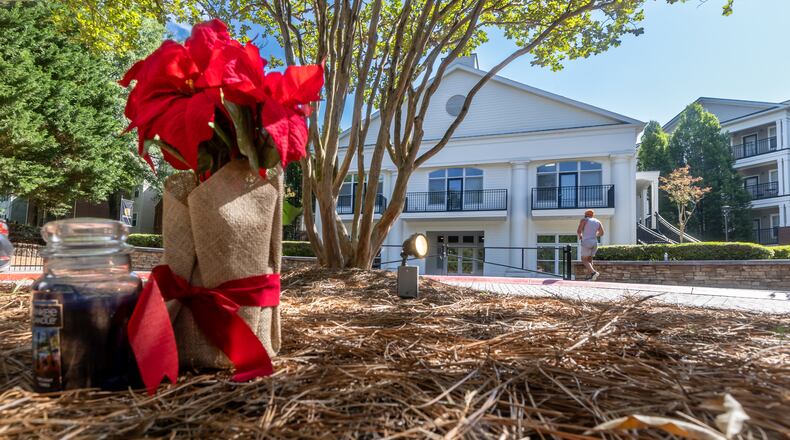 A poinsettia and candle were placed May 20 in the round driveway in the back of the Austin Residence Complex at Kennesaw State University, where Kennesaw State University student Alasia Franklin was shot to death during a dispute on campus Saturday. (John Spink/The Atlanta Journal-Constitution)