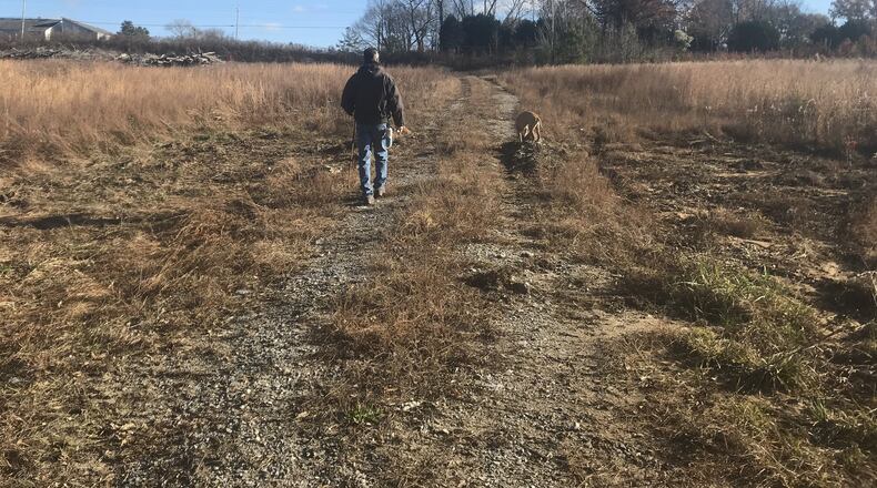 Joe Peery started out biking on the trails at Intrenchment Creek Park, and now he is part of a group of advocates who lead tours and push for conservation of the park as a natural greenspace. He and his dog, Mr. Butters, walk on a nearby parcel of land owned by Blackhall movie studio that is part of a proposed land swap with DeKalb County that would allow the company to build on a portion of the park. TIA MITCHELL/TIA.MITCHELL@AJC.COM