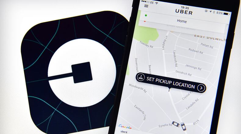 LONDON, ENGLAND - AUGUST 03: The Uber home page is displayed on an iPhone next to the company logo on a computer screen on August 3, 2016 in London, England. (Photo by Carl Court/Getty Images)