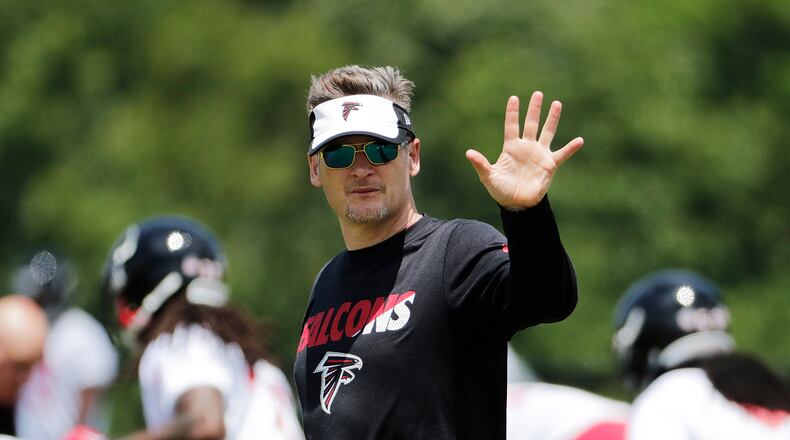 Atlanta Falcons general manager Thomas Dimitroff waves while walking across the field during a football practice Monday, May 23, 2016, in Flowery Branch. (AP Photo/David Goldman)
