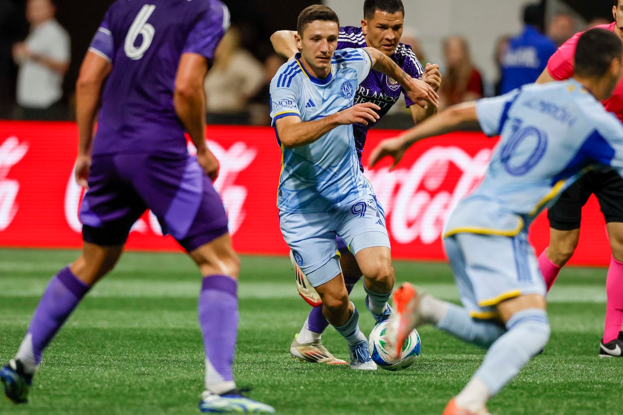 Atlanta United midfielder Bartosz Slisz (center) — pictured dribbling in traffic against Orlando City in May — was sold to Brøndby for $3.5 million. (Miguel Martinez/AJC 2025)