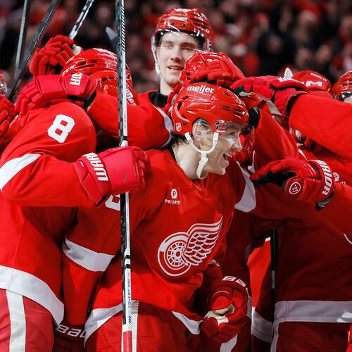 Detroit Red Wings right wing Patrick Kane, center, is surround by teammates after recording his 1,375th point to pass Mike Modano and break the NHL record for points by a player born in the United States, during the second period of an NHL hockey game Thursday, Jan. 29, 2026, in Detroit. (AP Photo/Duane Burleson)