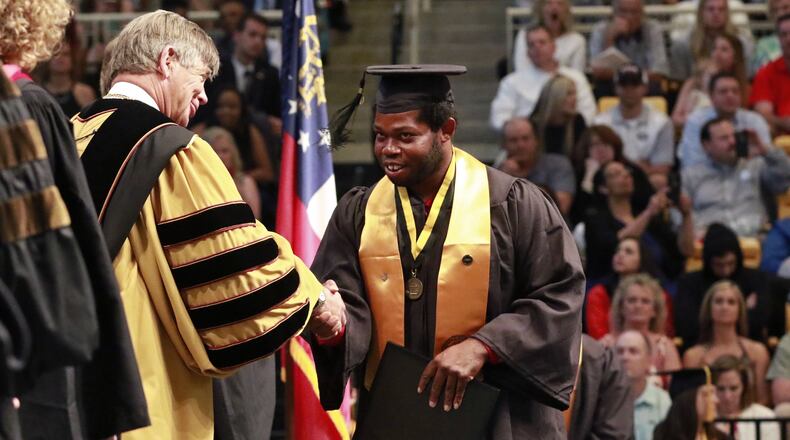 David Bennett is congratulated by University President Daniel Papp as he receives his Bachelor of Arts in Theatre and Performance Studies. Pass announced he is leaving the university after leading it for 10 years. BOB ANDRES / BANDRES@AJC.COM