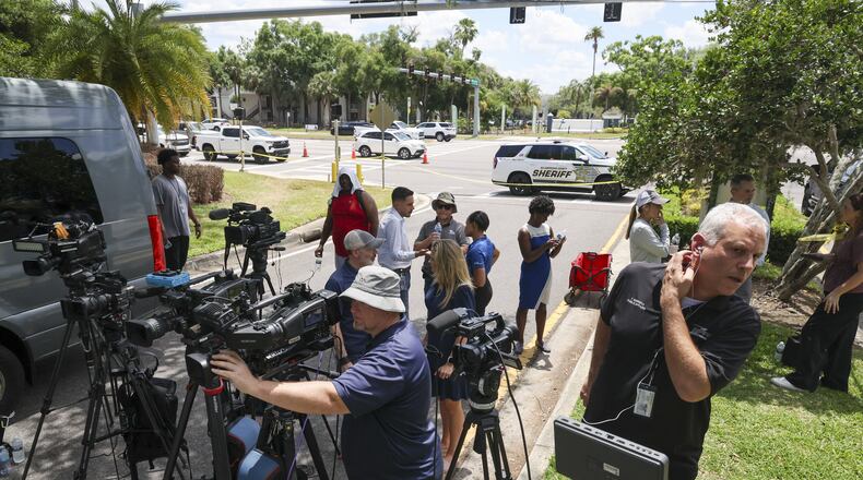 Members of the media document detectives and deputies with the Hillsborough County Sheriff's Office as they investigate inside the Lake Forest subdivision of Tampa, Fla., on Friday, April 24, 2026, where authorities said a man was taken into custody after barricading himself inside a home, in connection to the search for two missing University of South Florida graduate students. (Douglas R. Clifford/Tampa Bay Times via AP)