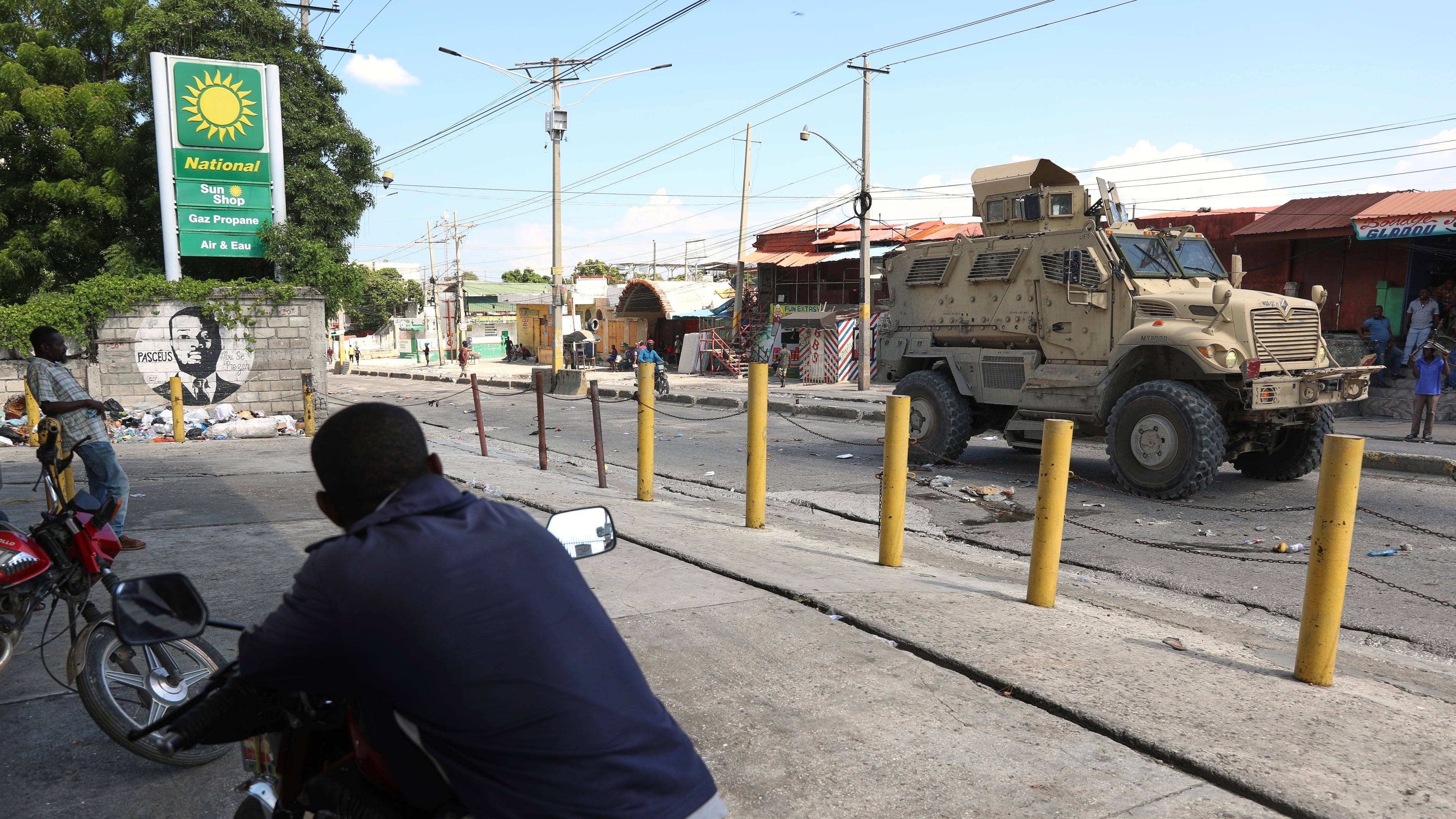 Residents watch a Kenyan police armored vehicle patrolling in Port-au-Prince, Haiti, Tuesday, Sept. 2, 2025. (AP Photo/Odelyn Joseph)