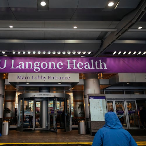 FILE - Health care workers walk in and out of the entrance at NYU-Langone Hospital on Dec. 14, 2020, in New York. (AP Photo/Kevin Hagen, File)