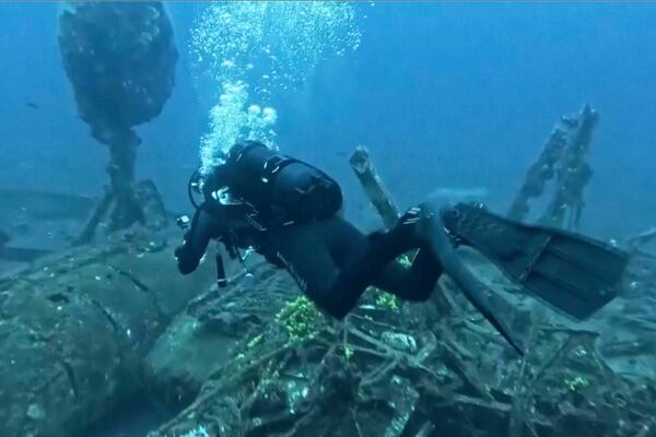In this frame grab made from video, diver Toni Kuran swims by the wreck of a sunken 18th-century boat after it was discovered by chance in April near the stone walls of Croatia’s medieval city of Dubrovnik, Croatia, Tuesday, June 24, 2025. (Nova TV via AP)