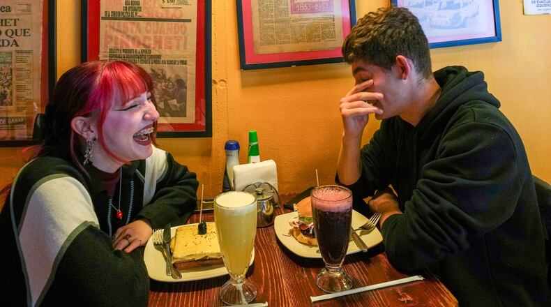 FILE - A couple sit in a cafe in Santiago, Chile, on Nov. 6, 2025. (AP Photo/Esteban Felix, File)