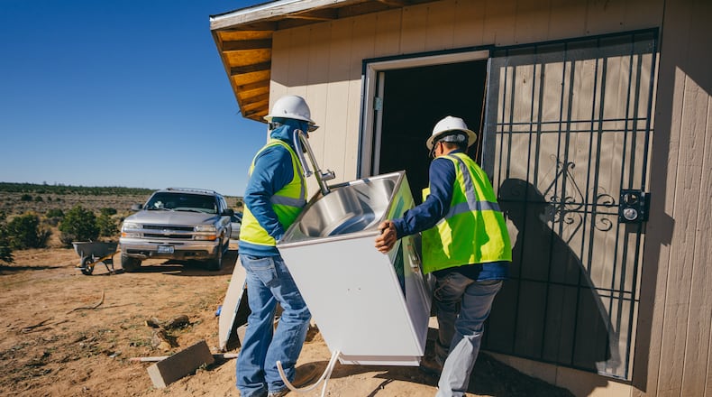 The CDC Foundation's projects have included work supporting safe drinking water, including among communities with fewer health resources.  In this photo, Navajo Water Project staff working with a CDC Foundation project carry a sink into a household during a home water system installation. (Photo courtesy of DigDeep via the CDC Foundation)