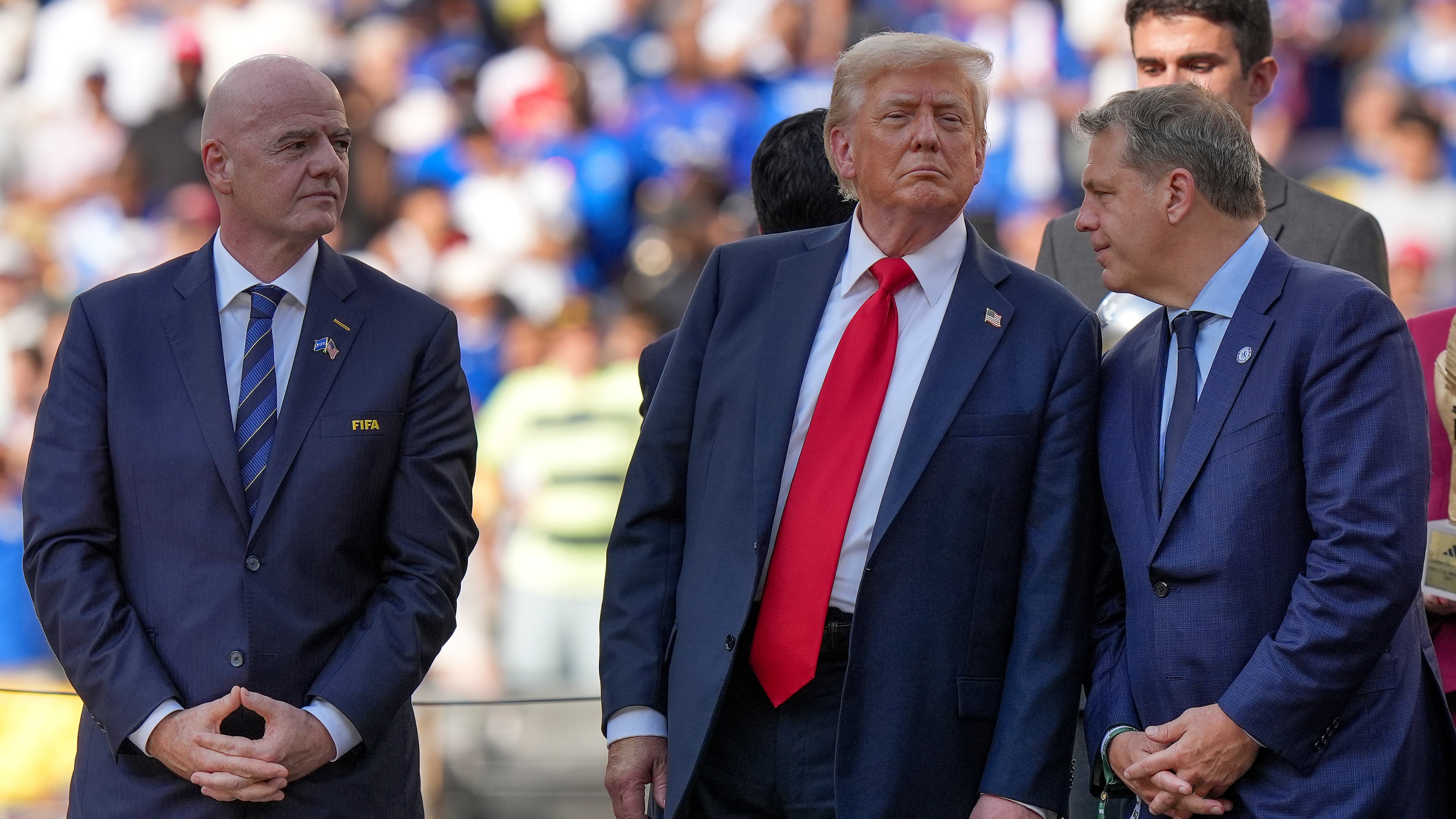 FILE - President Donald Trump, center, talks with Chelsea football club owner Todd Boehly, right, as FIFA president Gianni Infantino, left, looks on before the trophy ceremony of the Club World Cup final soccer match in East Rutherford, N.J., Sunday, July 13, 2025. (AP Photo/Frank Franklin II, File)