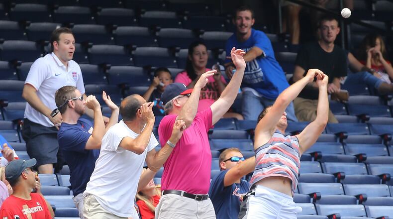 Braves fans, surrounded by many empty seats, seek a foul ball during July 5 game against the Phillies at Turner Field. Photo by Curtis Compton / ccompton@ajc.com
