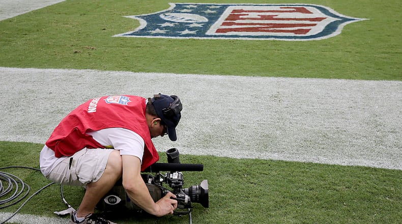 A camera man films the Atlanta Falcons in warm up before playing against the Houston Texans Aug. 16, 2014 in Houston, Texas.