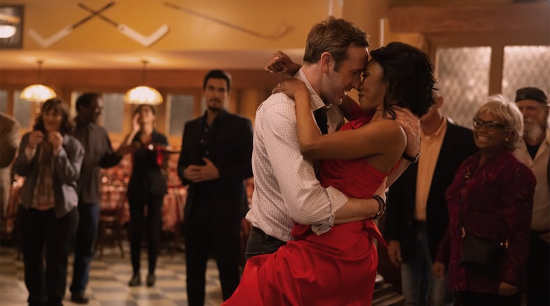 Gabrielle Dennis and Chris O’Dowd in "The Big Door Prize," now streaming on Apple TV+. Josh Segarra is in the background. APPLE TV+
